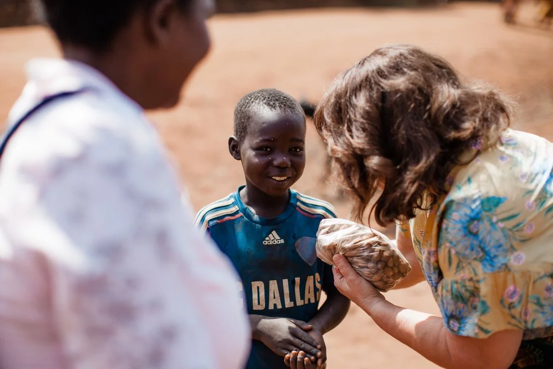 A handful of food shared with a smiling child in Chilinza Village